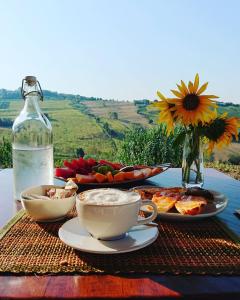 a table with plates of food and a bottle of water at Casale dei Cinque Colli in Ostra