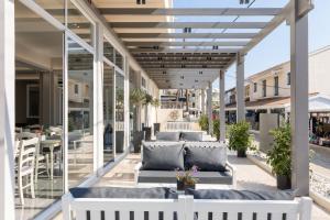 un patio con divani e tavoli su un edificio di Melina Oasis Boutique Hotel a Kassiopi