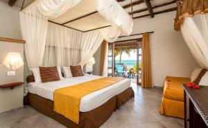 a bedroom with a bed and a view of the ocean at Karafuu Beach Resort & Spa in Pingwe