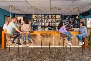 un groupe de personnes assises dans un bar dans l'établissement Stayokay Hostel Texel, à Den Burg