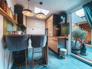 a kitchen with a bar with two black chairs at Cosy Studio in Newmarket