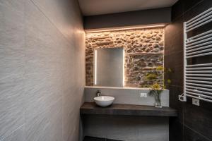 uma casa de banho com um lavatório e um espelho em Astoria Boutique Apartments em Bolonha