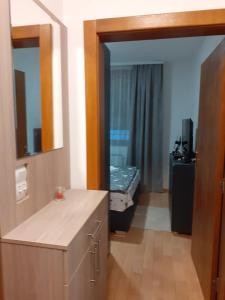 ein Bad mit einem Waschbecken und ein Bett in einem Zimmer in der Unterkunft Apartman Nada de lux in Vrnjačka Banja