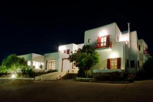 a large white house at night with its lights on at Hotel Charissi in Mikonos