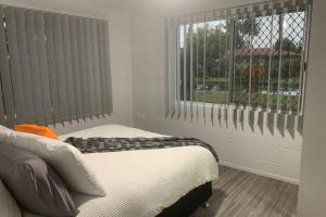 a bedroom with a bed and a window at Andergrove Home with a Garden View-Wi-fi & Netflix in Andergrove