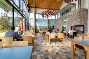 a rendering of a restaurant with people sitting at tables at Stayokay Hostel Texel in Den Burg