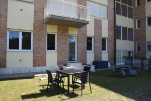 eine Terrasse mit einem Tisch und Stühlen vor einem Gebäude in der Unterkunft Residence Il Piviere app 7 with private garden in Calambrone