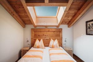 2 Betten in einem Schlafzimmer mit Dachfenster in der Unterkunft Apartment Bawiglbach Grosskarneid in Lüsen