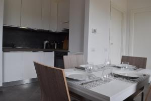 una cocina con una mesa con copas de vino. en Residence Il Piviere app 7 with private garden, en Calambrone