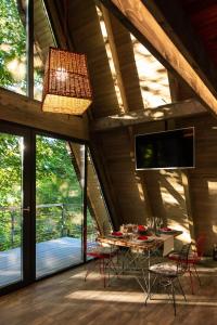 a dining room with a table and chairs and windows at Hai La Munte Bran in Bran