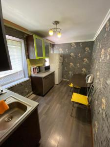 a kitchen with a sink and a table in a room at Apartment na Kirova 37 in Pyatigorsk