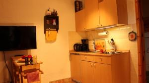 een keuken met bruine kasten en een tv en een aanrecht bij Ferienwohnung Haus Nadja in Winterberg