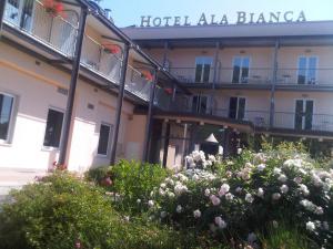 un hotel con fiori di fronte a un edificio di Hotel Ala Bianca ad Ameglia