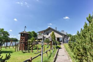 un parque con parque infantil y una casa en Kurėnų Užeigos Svečių Namai, en Kurėnai