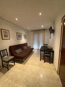 a living room with a couch and a table at Apartamentos Mitus in Canet de Mar