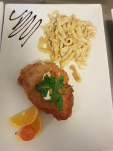 a plate of food with a piece of meat and pasta at Alemannenhof Hotel Engel in Rickenbach