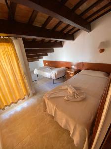 a bedroom with two beds and a window at Apartamentos Mitus in Canet de Mar