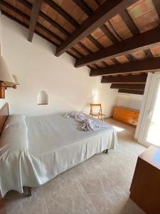 Schlafzimmer mit einem großen weißen Bett und einer Holzdecke in der Unterkunft Apartamentos Mitus in Canet de Mar