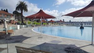 a large swimming pool with umbrellas in a resort at Gateway to the Surf Coast and Geelong in Geelong