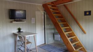 a staircase in a room with a table and a television at Urmas Rehvid Holiday Home in Põlva