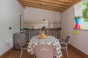 una cocina con una mesa con un bol de fruta. en Casa Rural El Níspero, en Cortes de la Frontera