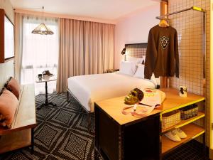 パリにあるMama Shelter Paris Westの大きなベッドとテーブル(Aezvous付)が備わるホテルルームです。