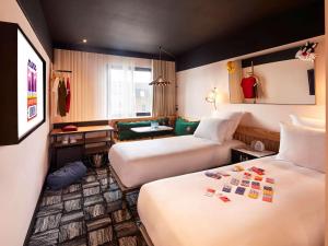 um quarto de hotel com duas camas e um sofá em Mama Shelter London - Shoreditch em Londres