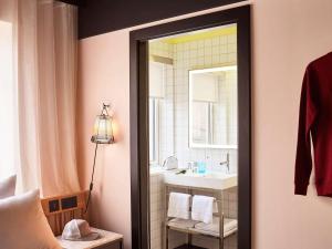 a bathroom with a sink and a mirror at Mama Shelter London - Shoreditch in London