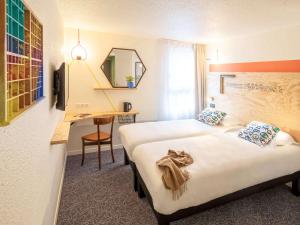 博恩的住宿－greet Hotel Beaune，酒店客房配有两张床和一张书桌