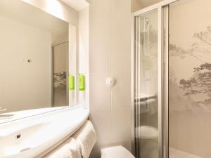 a white bathroom with a sink and a shower at greet Hotel Beaune in Beaune