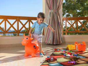 een jonge jongen die met speelgoed speelt in een kamer bij Movenpick Taba Resort & Spa in Taba