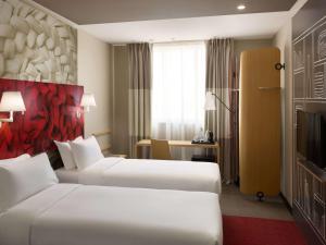 a hotel room with two beds and a television at ibis Jeddah City Center in Jeddah