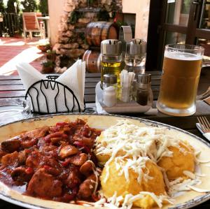 een bord eten op een tafel met bier bij Casa Ardeleană in Ploieşti