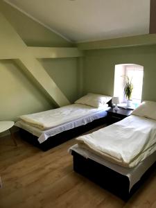 two beds in a room with green walls at Apartamenty Mieszkaniowe Kadrema in Rybczewice