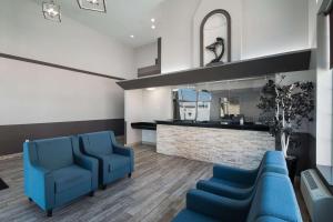 a waiting room with blue chairs and a mirror at Quality Inn Midvale - Salt Lake City South in Midvale