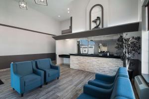 una sala de espera con sillas azules y un espejo en Quality Inn Midvale - Salt Lake City South, en Midvale