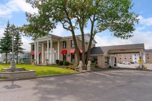 a building with a tree in front of it at Econo Lodge Montreal-Brossard in Brossard