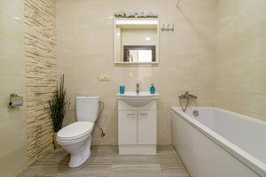 a bathroom with a toilet and a sink and a tub at Apartamentai 555 in Vilnius