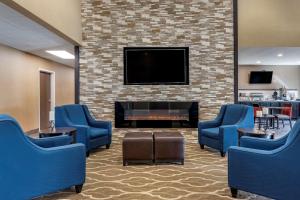 a waiting room with blue chairs and a fireplace at Comfort Inn in Crawfordsville