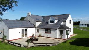 a white house with a patio and a table at Spacious 3-Bedroom 3-bathroom country cottage in Haverfordwest