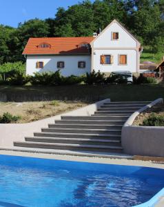 ein weißes Haus mit einer Treppe neben einem Pool in der Unterkunft Revlanda Vendégház in Zalaszentgrót