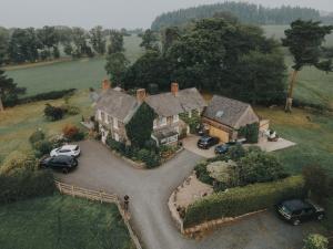 an aerial view of a house with cars parked in the driveway at Mid-Wales Farmhouse, swimming pool, tranquil countryside views, sleeps 14 in Meifod