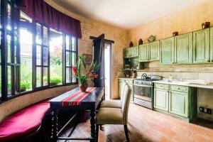 a kitchen with green cabinets and a table and chairs at Casa Serenidad in Antigua Guatemala