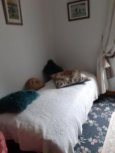 Un dormitorio con una cama blanca con almohadas. en Manoir de la Peignie, en Merdrignac