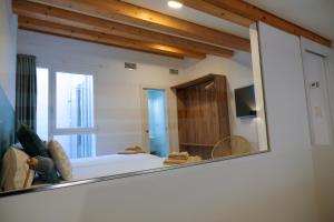 a mirror in a room with a bed and a window at Silken Casa Platerias Siglo XV in Zaragoza