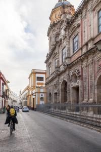 a person riding a bike down a street next to a building at Bordador in Seville