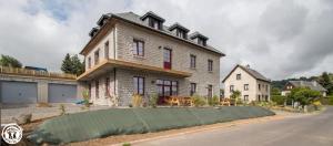 a large brick house on the side of a street at Gîte de Granit ROSE in Besse-et-Saint-Anastaise