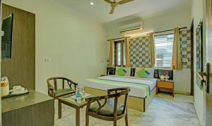 1 dormitorio con cama, escritorio y mesa en Itsy By Treebo - Swastika Inn Sector 26, en Noida