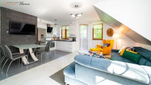 uma sala de estar com um sofá azul e uma cozinha em Wonder Home - Apartamenty Leśny Dom z balkonami niedaleko centrum - w cichej okolicy, blisko szlaków i terenów leśnych em Karpacz