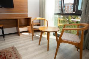 泰基爾達的住宿－BUSINESS EXPRESS HOTEL，客房设有桌子、椅子和书桌。